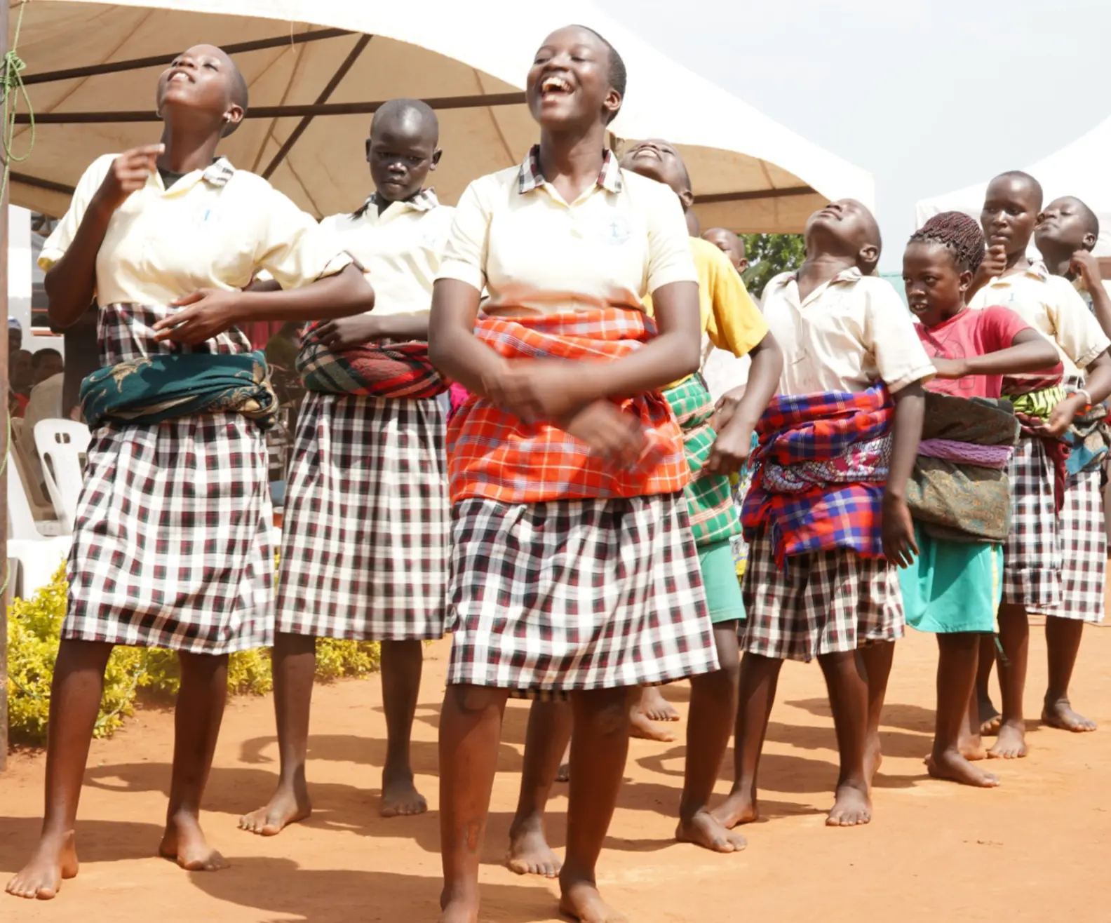 Girls in school uniforms singing and dancing together