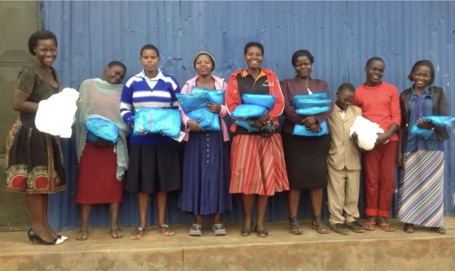 Mothers and children holding supplies received through their local church